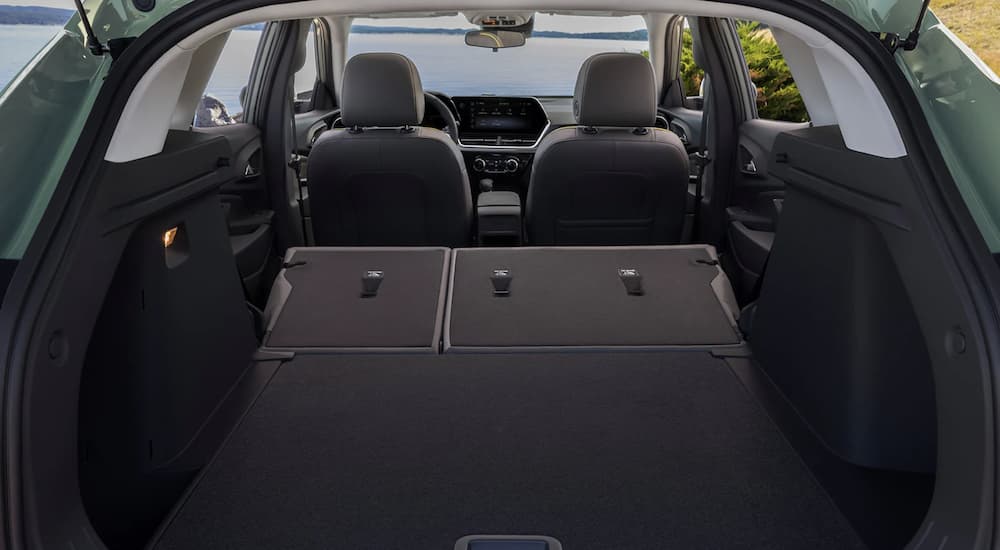 The black interior of a 2024 Chevy Trax shows the back seats folded down.