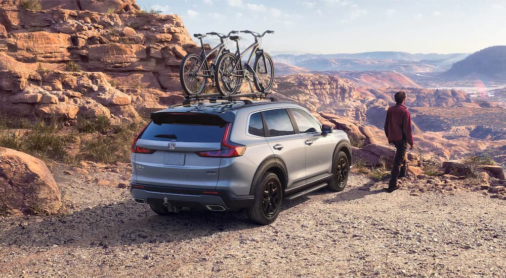 A grey 2023 Honda CR-V Hybrid Sport Touring is shown overlooking a canyon.
