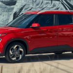 A red 2022 Hyundai Venue for sale is shown parked near a brick wall.