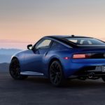 A blue 2023 Nissan Z is shown from the rear overlooking a mountain view.