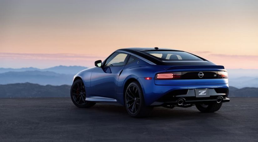 A blue 2023 Nissan Z is shown from the rear overlooking a mountain view.