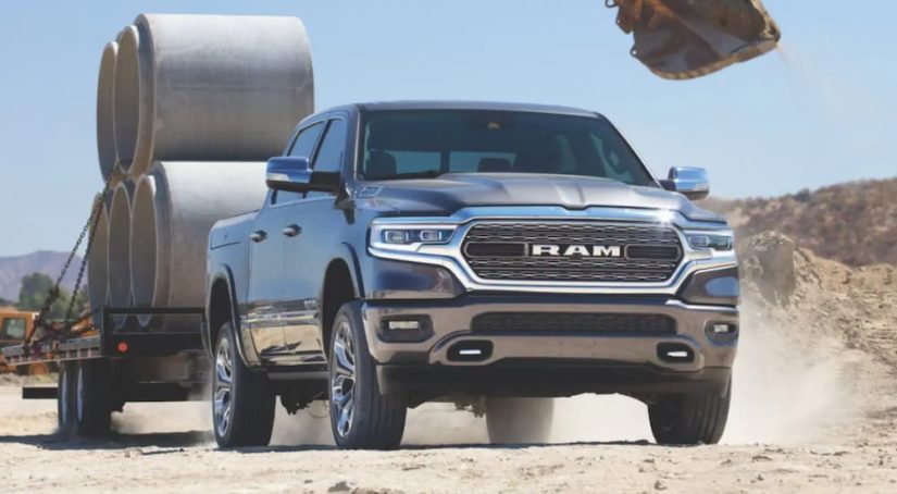 A blue 2021 Ram 1500 is shown towing a large trailer.