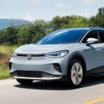 A grey 2022 Volkswagen ID. 4 is shown driving on an open road.