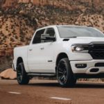 A white 2023 Ram 1500 is shown from the front at an angle while parked.