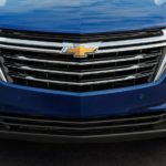A close up of the grille on a blue 2023 Chevy Equinox is shown during online Chevy Equinox sales.