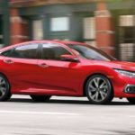 A red 2021 Honda Civic touring is shown from the side after leaving a dealer that handles online Honda Civic sales.