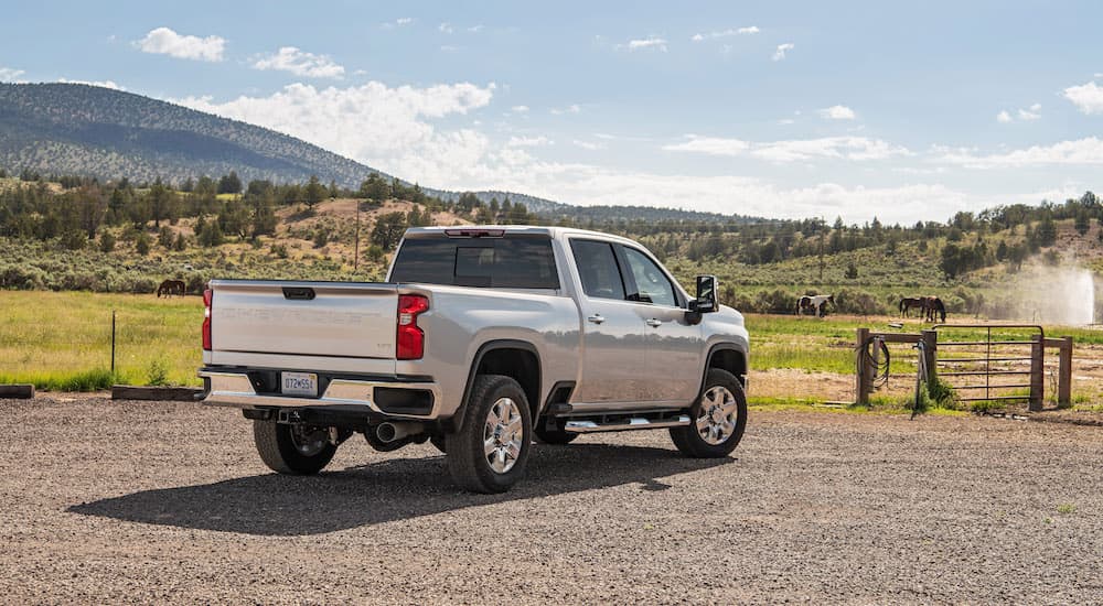 A silver 2023 Chevy Silverado 2500 HD is shown from the rear at an angle.