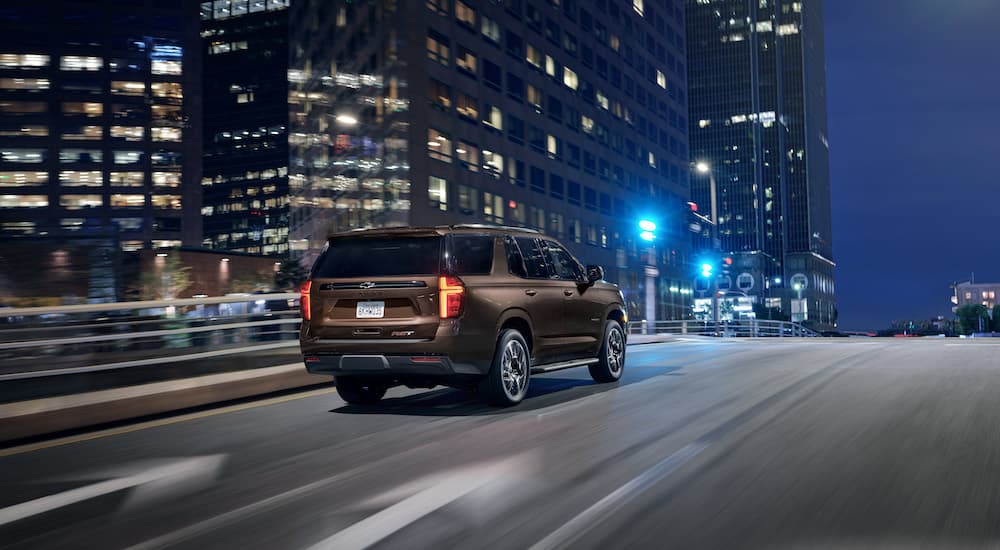 A brown 2022 Chevy Tahoe is shown from the rear at an angle after leaving a Chevy SUV dealer.