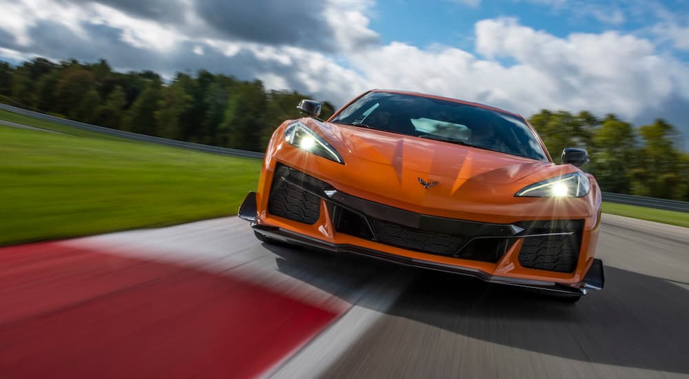 An orange 2023 Chevy Corvette Z06 is shown from the front on a race track.