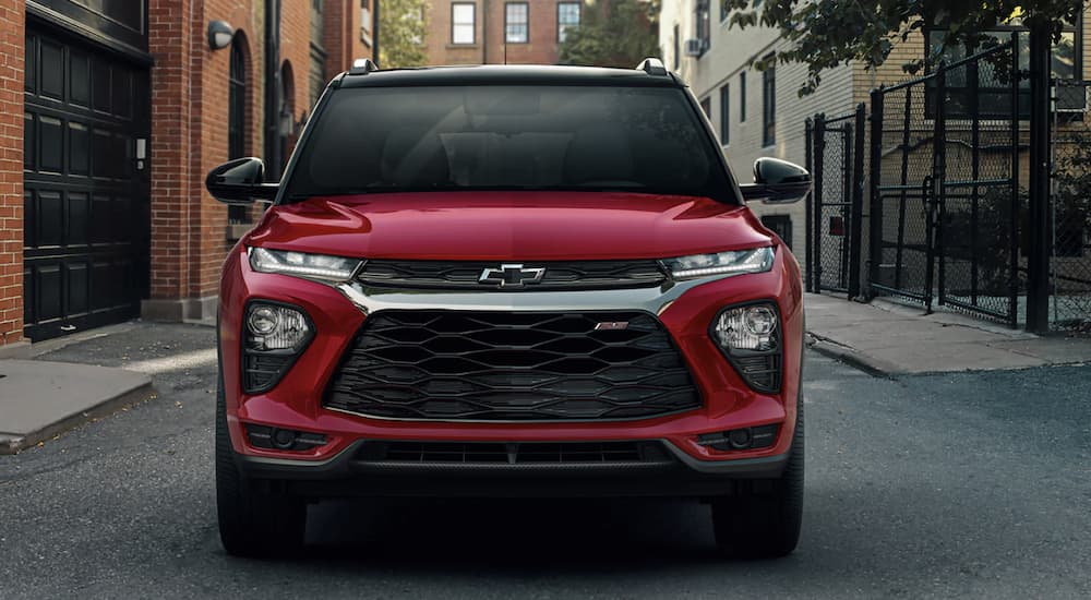 A red 2023 Chevy Trailblazer RS is shown from the front driving through a city.