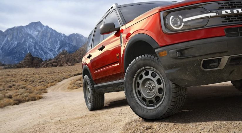 A close up of a red 2023 Ford Bronco Sport driving on a dirt road is shown.