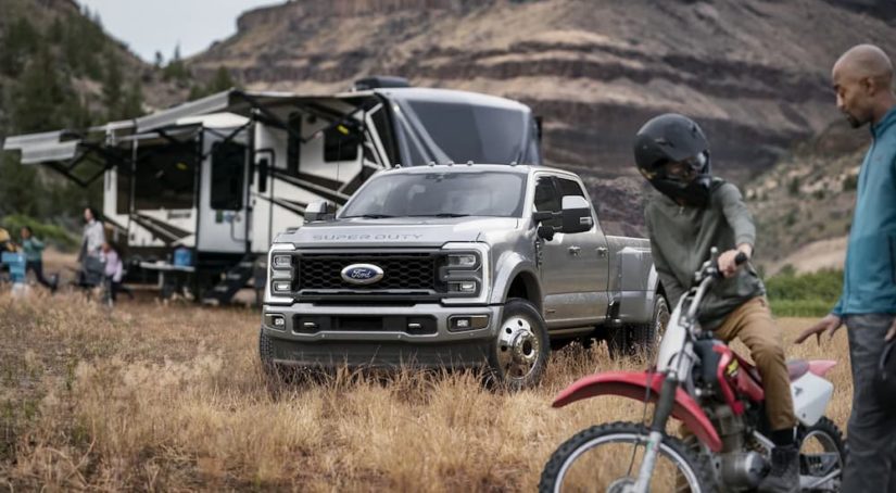 A silver 2023 Ford F-450 is shown parked at a remote campsite.