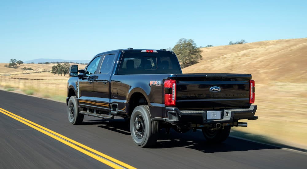 A black 2023 Ford F-250 FX4 is shown from the rear at an angle.