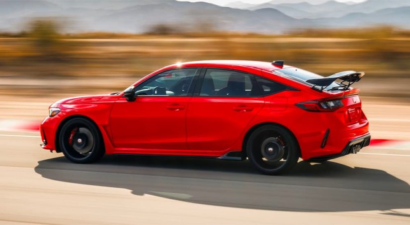 A red 2023 Honda Civic Type R is shown from the side on a racetrack.