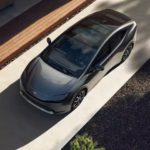 A grey 2023 Toyota Prius Prime is shown from a high angle parked in a driveway.