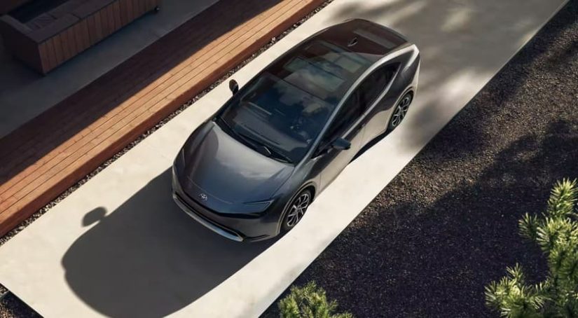 A grey 2023 Toyota Prius Prime is shown from a high angle parked in a driveway.