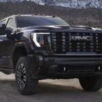 A black 2024 GMC Sierra 2500 HD is shown driving off-road.