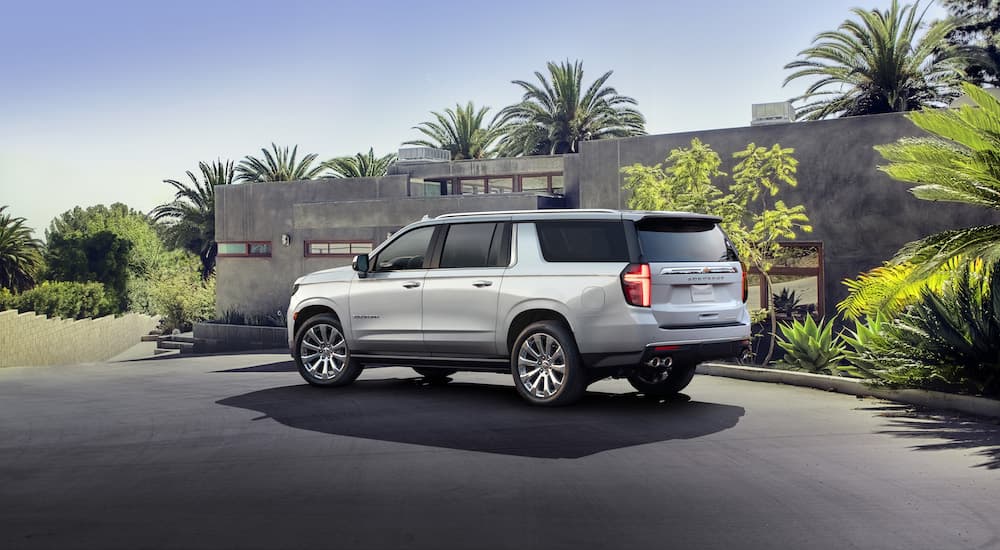 A silver 2021 Chevy Suburban is shown in a driveway after leaving a certified used SUV dealer.