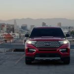 A red 2023 Ford Explorer Limited Hybrid is shown from the front parked on a parking garage.