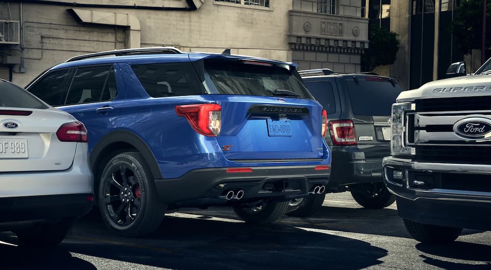 A blue 2023 Ford Explorer ST is shown in a parking spot on a busy street.