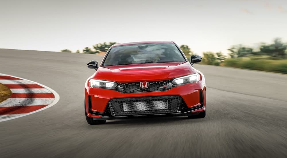 A red 2023 Honda Civic Type R is shown from the front on a racetrack.