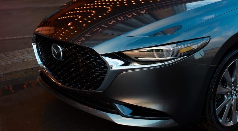 A close up shows the grille on a grey 2022 Mazda3.