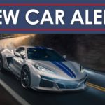 A silver 2024 Chevy Corvette E-Ray 3LZ is shown rounding a corner under a new car alert banner.