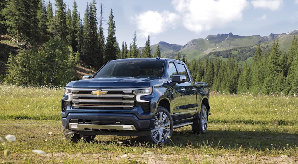 A blue 2023 Chevy Silverado 1500 High Country is shown from the front at an angle.