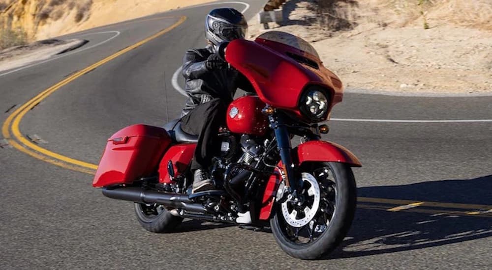 A red 2022 Harley-Davidson Street Glide is shown from the front at an angle after leaving a dealer that has a Certified Pre-Owned Harley-Davidson near you.