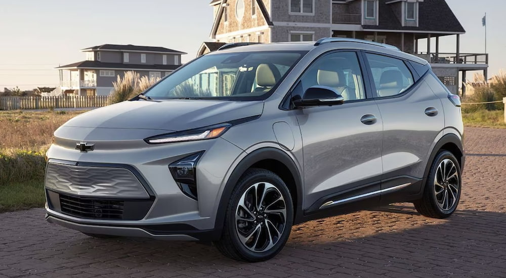 A silver 2023 Chevy Bolt EUV is shown from the side parked in front of a beach house.