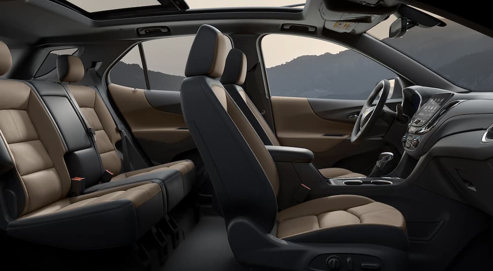 The black and brown interior of a 2023 Chevy Equinox shows two rows of seating.
