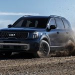 A blue 2023 Kia Telluride is shown off-roading.