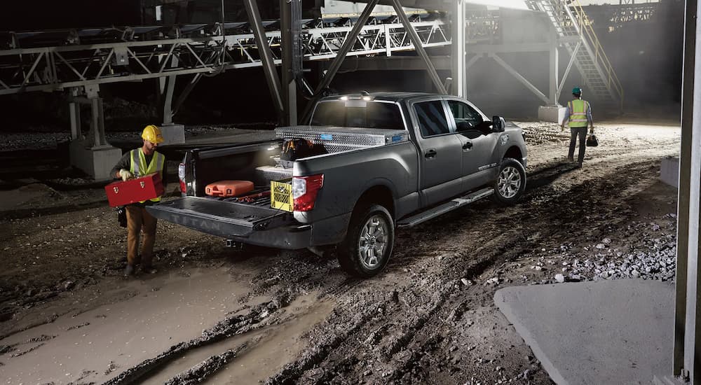 A grey 2023 Nissan Titan XD is shown from the rear at a construction site at night.