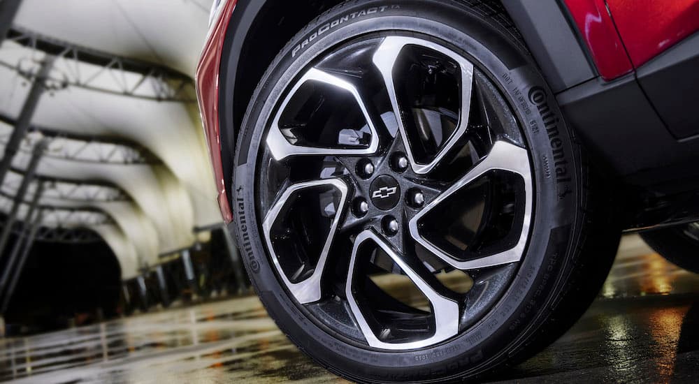 A close up shows the rim and tire on a red 2024 Chevy Trax RS.