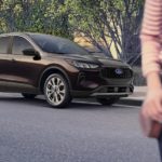 A brown 2023 Ford Escape is shown parked on the side of a city street.