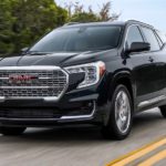 A black 2023 GMC Terrain Denali is shown on an open road after leaving a GMC SUV dealer.