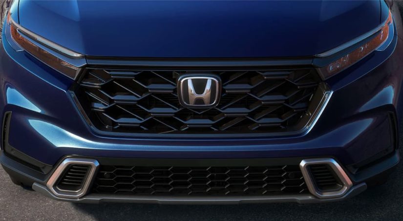 A close up shows the grille on a dark blue 2023 Honda CR-V Hybrid Sport Touring after leaving a Honda dealer.