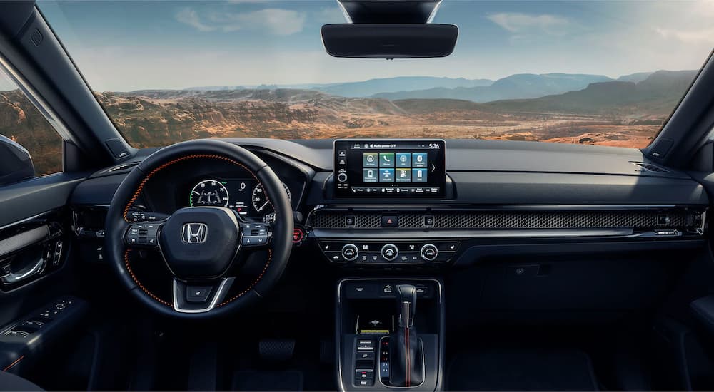 The dash and interior is shown in a 2023 Honda CR-V Hybrid Sport Touring.