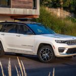 A white 2023 Jeep Grand Cherokee for sale is shown parked in a driveway.