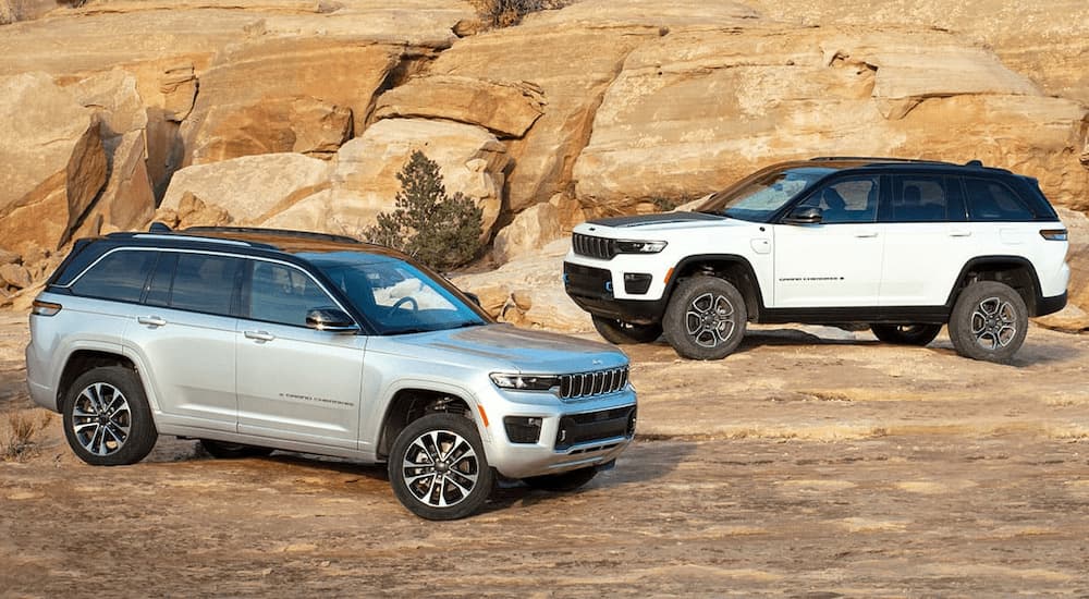 A silver 2023 Jeep Grand Cherokee and a white 2023 Jeep Grand Cherokee 4xe are shown parked.