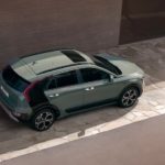 A green 2023 Kia Niro Hybrid is shown from a high angle next to a modern home.