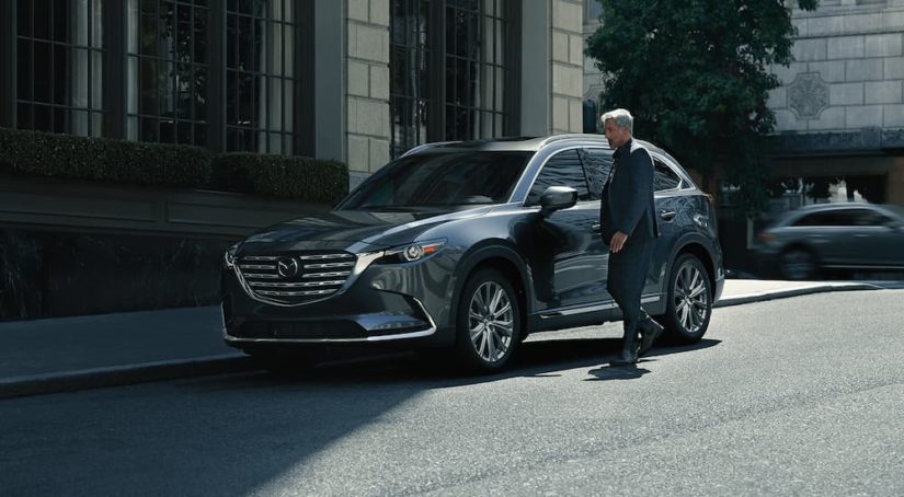 A grey 2023 Mazda CX-9 for sale is shown parked on the side of a street.