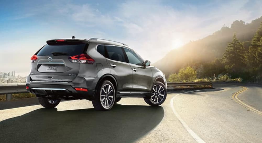 A grey 2018 Nissan Rogue is shown parked on the side of a highway.