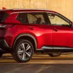 A red 2021 Nissan Rogue Platinum is shown from the side after viewing used Nissan Rogue's for sale.