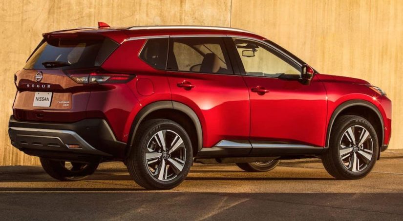 A red 2021 Nissan Rogue Platinum is shown from the side after viewing used Nissan Rogue's for sale.