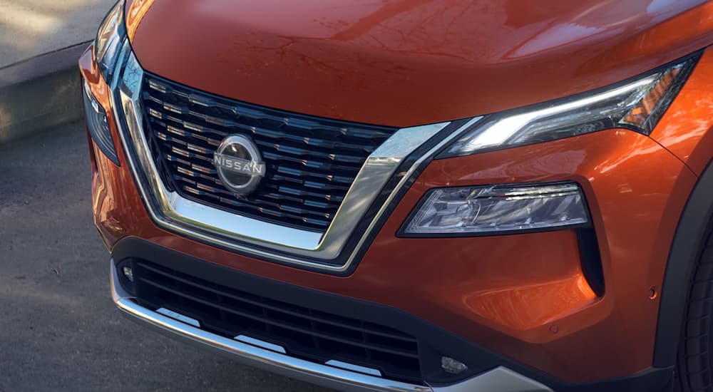 A close up of the grille of an orange 2022 Nissan Rogue is shown.