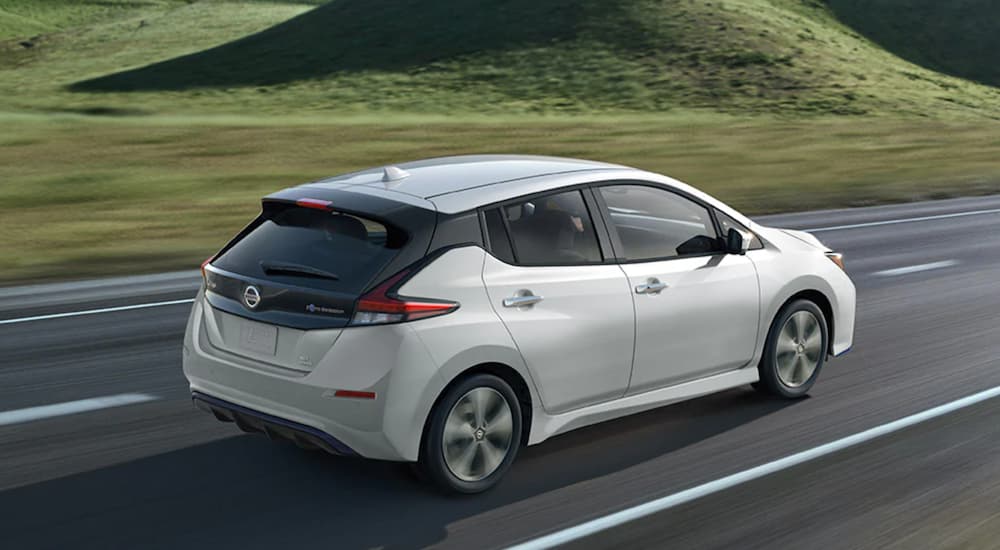 A white 2023 Nissan LEAF is shown from the rear at an angle after leaving a Nissan dealer.