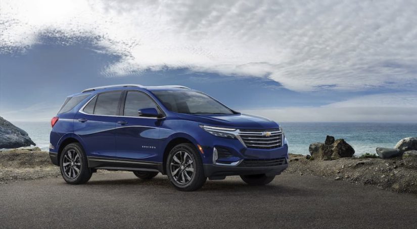 A blue 2023 Chevy Equinox Premier is shown from the side during a 2023 Chevy Equinox vs 2023 Toyota RAV4.