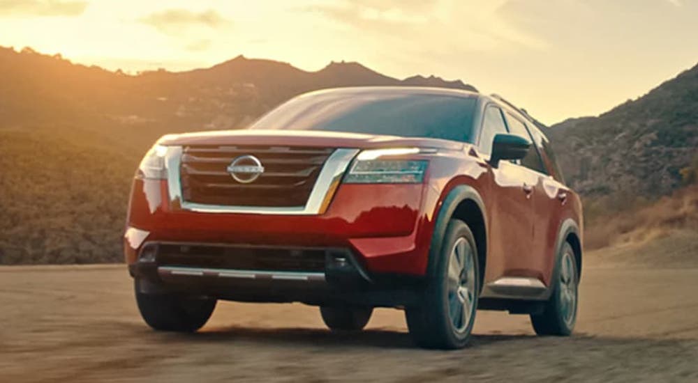 A red 2023 Nissan Pathfinder is shown from the front.