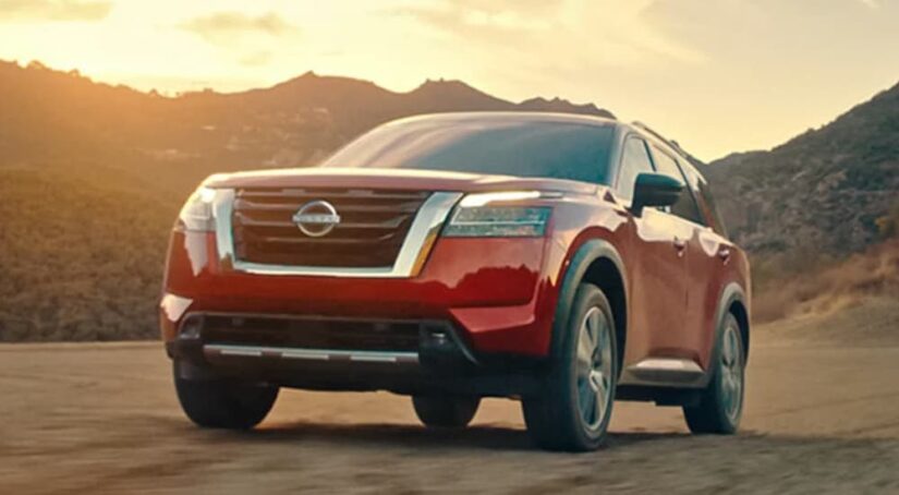 A red 2023 Nissan Pathfinder is shown from the front after leaving a Nissan Pathfinder dealer.